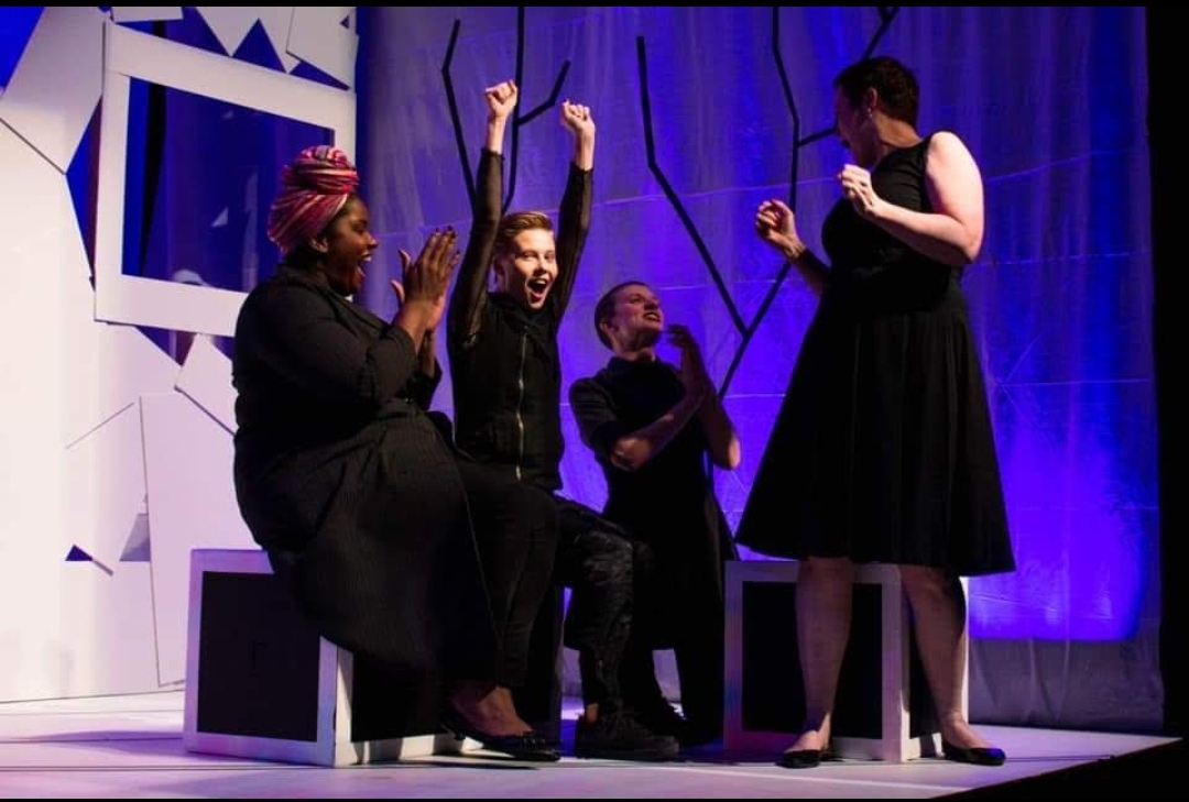 A burst of shared joy under blue stage lights. This ensemble moment captures the quick reactions, physical expression, and connection that make live theater feel alive.